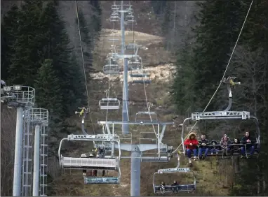  ?? (AP/Armin Durgut) ?? People ride the cable cars above the ski track without any snow on Bjelasnica mountain near Sarajevo, Bosnia, earlier this month.