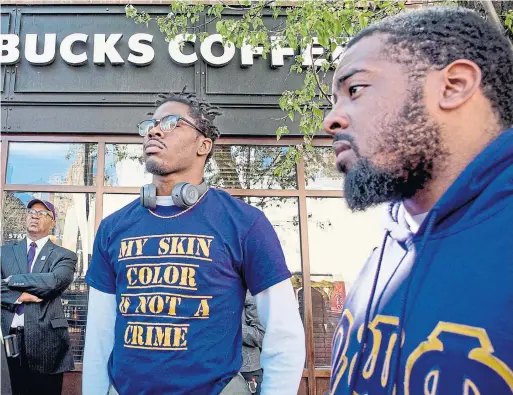  ?? TOM GRALISH/THE ASSOCIATED PRESS ?? Fraternity members Reese Tillman, right, and Bucketo Mitchell listen during a rally outside the Starbucks where one of their fraternity brothers was arrested.