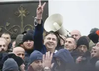  ?? (Gleb Garanich/Reuters) ?? EX-GEORGIAN PRESIDENT Mikheil Saakashvil­i flashes a victory sign moments after supporters forcibly freed him from police custody in Kiev, Ukraine, yesterday.