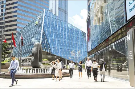  ??  ?? Office workers walk past an electronic board showing shares prices at the financial district in Hong Kong, Aug 5. China’s yuan fell further Wednesday after
hopes among financial traders that its decline was stabilizin­g helped to calm jittery global markets. (AP)