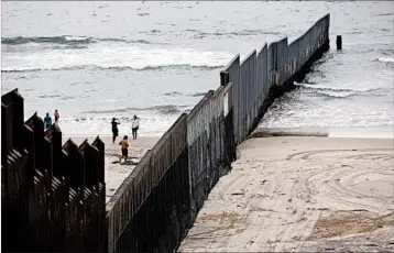  ?? GARY CORONADO/LOS ANGELES TIMES ?? Beach-goers take photos on the Mexican side of the fence, which is patrolled on the northern side by U.S. border agents.