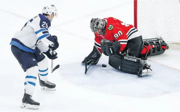  ?? KAMIL KRZACZYNSK­I / THE ASSOCIATED PRESS ?? Blackhawks goalie Scott Foster makes a save against the Winnipeg Jets’ Paul Stastny during the third period of their game Thursday night in Chicago. Foster stopped all seven shots he faced in his pro hockey debut as an emergency backup.