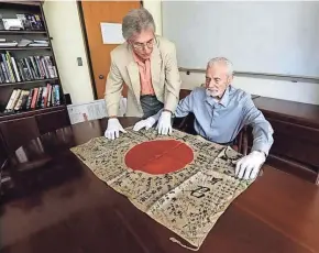  ?? ASSOCIATED PRESS ?? World War II veteran Marvin Strombo (right) and Obon Society executive director Rex Zika lay out a Japanese flag with names written on it in Portland, Ore. Strombo, 93, recovered the flag from a dead Japanese soldier in the Pacific more than 70 years...