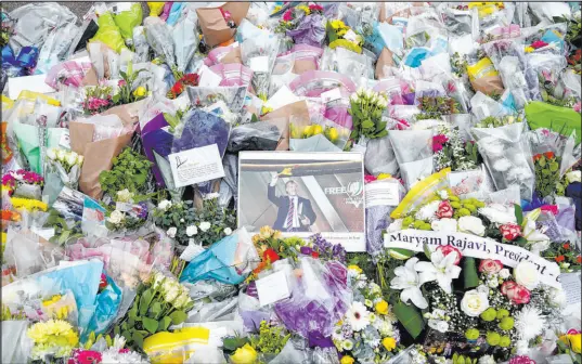  ?? Kirsty O’connor The Associated Press ?? A photograph of member of Parliament David Amess is seen Sunday among the flower tribute near the Belfairs Methodist Church in Eastwood Road North, where Amess died after he was stabbed several times on Friday, in Leigh-on-sea, Essex, England.