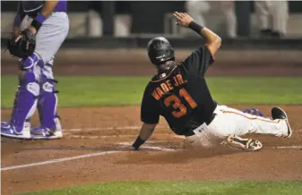  ?? Carlos Avila Gonzalez / The Chronicle ?? Outfielder LaMonte Wade Jr., acquired from the Twins before spring training, slides across home for the Giants’ only run of the game in the sixth inning against the Dodgers.