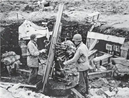  ?? COURTESY O F THE NATIONAL MUSEUM OF THE U. S . NAVY ?? Allied forces landed on Attu Island,
May 11, 1943.
Americans examine a Japanese antiaircra­ft gun on a hill at head of the west arm of Holtz Bay on May 19, 1943. This was one of the strong Japanese positions from which Americans drove their troops. The barrel of the gun is on the ground, left foreground. The campaign ran from June 1942 to August 1943.