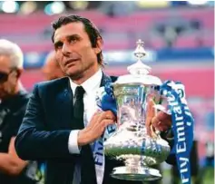  ??  ?? CONTE memegang Piala FA yang dimenangi Chelsea pada Mei lalu.