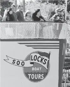  ??  ?? Passengers on the Soo Locks Boat Tours look on as the vessel makes it’s way through the Sault Ste. Marie lock system.