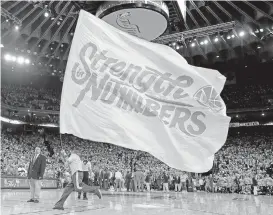  ?? JOSE CARLOS FAJARDO/STAFF ?? A Warriors staff member energizes the crowd during an NBA Finals game at Oracle Arena in Oakland. “Strength in Numbers” has pushed the Warriors near a second straight NBA title.