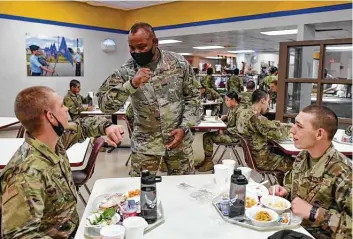  ?? Photos by Billy Calzada / Staff photograph­er ?? Col. Michael Newsom, commander of the 737th Training Group, elbow-bumps graduates of the basic military training program during their Thanksgivi­ng meals at the Joint Base San Antonio-lackland.