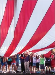  ?? RECORDER PHOTOS BY CHIEKO HARA ?? Left: The new American flag is presented by Portervill­e American Legion Post 20 at the 37th annual Flag Day Celebratio­n Thursday. Above: Children help fold the old flag at the annual Flag Day ceremony Thursday, June 14. City Councilmem­ber Cameron Hamilton was the guest speaker.