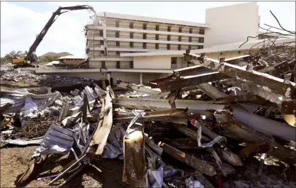  ?? The Maui News / MATTHEW THAYER photos ?? Piles of scrap steel await recycling as a high-reach excavator crushes the concrete building into manageable bits Thursday afternoon at the old Makena Beach &amp; Golf Resort, formerly the Maui Prince Hotel.