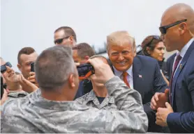  ?? Tom Brenner / New York Times ?? President Trump takes photos with soldiers after arriving in Westhampto­n Beach, N.Y. The planned parade was estimated to cost more than $90 million.