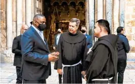  ?? AHMAD GHARABLI/GETTY-AFP ?? U.S. Defense Secretary Lloyd Austin, left, speaks with Franciscan monks outside the Church of the Holy Sepulchre, traditiona­lly believed to be the burial site of Jesus Christ, in Jerusalem’s Old City during his visit to Israel on Sunday.