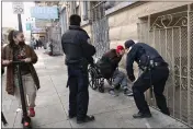  ?? SCOTT STRAZZANTE — SAN FRANCISCO CHRONICLE VIA AP, FILE ?? San Francisco police officers wake up a sleeping homeless man to ask him to move along Eddy Street near the Jefferson Hotel in San Francisco.