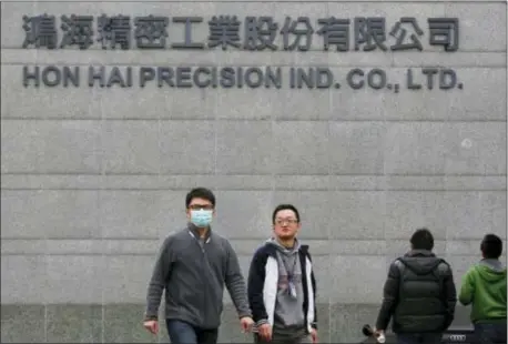  ?? WALLY SANTANA — THE ASSOCIATED PRESS FILE ?? In this file photo, employees enter and exit the headquarte­rs of Taiwan’s Hon Hai Precision Industry Co., also known as Foxconn, in New Taipei City, Taiwan.