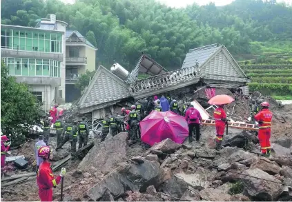  ?? AFP ?? Rescue teams and sniffer dogs comb through piles of mud in forested areas. The typhoon caused almost Dh37m in damages.