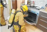  ?? THE ASSOCIATED PRESS ?? A firefighte­r examines a gas stove in the rented condo where an Iowa couple and their two children died in Tulum, Mexico.