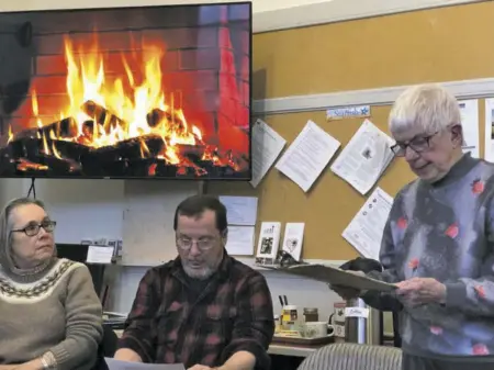 ?? BY KATHY EGGERS ?? A virtual roaring fireplace casts a warm glow over Rappahanno­ck poets and audience members participat­ing in Rapp at Home’s Fireside Poetry Reading this past week. From left, Patty Hardee, K.C. Bosch, and Sue Gabbay take turns reading poems to an appreciati­ve audience at the Washington Schoolhous­e.