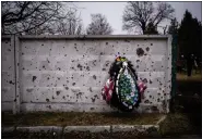 ?? AP PHOTO/ EMILIO MORENATTI ?? A wreath is photograph­ed leaning against a shrapnelda­maged wall in the cemetery where the funeral for Kasich Kostiantyn, 42, a senior lieutenant of 93rd Ukrainian brigade, is being held in Bucha, near Kyiv, Ukraine, Friday, Feb. 17, 2023.