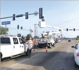  ?? Bill McLoud • Times-Herald ?? Crews were out early this morning at the Washington and Deaderick instersect­ion working on traffic lights. A crew member replaces a bulb for the southbound turn light.