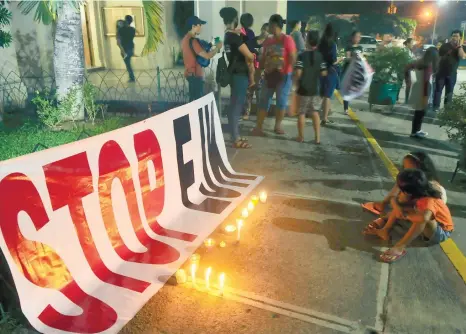  ?? (SUNSTAR FOTO/ARNI ACLAO) ?? LIGHT AGAINST EJK. Concerned citizens place a streamer and light candles outside the Redemptori­st Church in what they call a silent protest against extra-judicial killings in the country. They held the activity in celebratio­n of Internatio­nal Human Rights Day.
