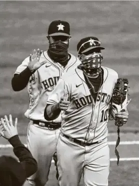  ?? Ezra Shaw / Getty Images ?? El cubano Yuli Gurriel (der.) y Abraham Toro saludan a sus compañeros luego del triunfo 5-4 de los Astros el martes ante los Atléticos en Oakland, California.