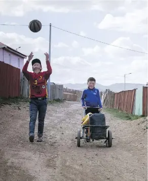  ??  ?? Children walk home after collecting water in a district in Ulaanbaata­r.