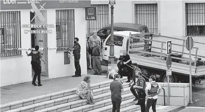  ??  ?? Agentes de la Guardia Civil precintan la oficina y conversan con testigos de lo ocurrido.