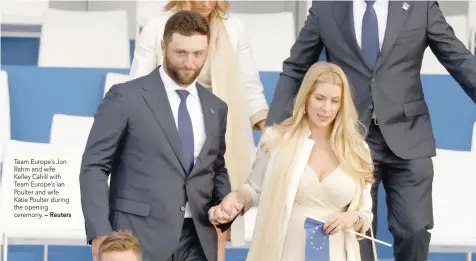  ?? — Reuters ?? Team Europe’s Jon Rahm and wife Kelley Cahill with Team Europe’s Ian Poulter and wife Katie Poulter during the opening ceremony.