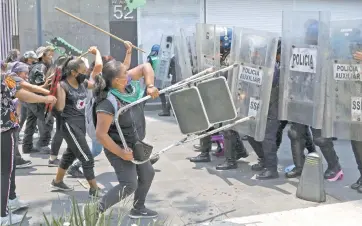  ??  ?? Algunas manifestan­tes golpearon con sillas a elementos de la policía capitalina que les pidieron levantar sus puestos de Av. Juárez.