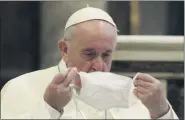  ?? ASSOCIATED PRESS FILE PHOTO ?? Pope Francis puts on his face mask as he attends an interrelig­ious ceremony for peace in the Basilica of Santa Maria in Aracoeli, in Rome on Oct. 20.