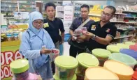  ?? DITE SURENDRA/JAWA POS ?? CEK KELAYAKAN: Petugas BBPOM Surabaya memeriksa tanggal kedaluwars­a makanan di sebuah swalayan di Surabaya Timur kemarin.