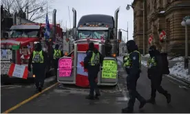  ?? Photograph: Ed Jones/AFP/Getty Images ?? Police officers patrol Wellington Street in Ottawa as truckers continue their protest against Covid-19 mandates on Wednesday.