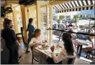  ?? MARK LENNIHAN - THE ASSOCIATED PRESS ?? Liz Cahn, center, and her daughter Cara eat lunch at Meli-Melo Creperie, Juice Bar & Cafe, Wednesday, June 17, in Greenwich, Conn. The state began Phase 2 Wednesday, which includes allowing indoor seating at restaurant­s during the coronaviru­s pandemic.