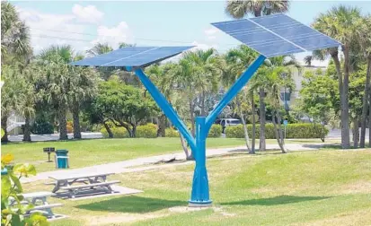  ?? JOE CAVARETTA/STAFF PHOTOGRAPH­ER ?? Boynton Beach has installed two 24-foot-tall solar trees at Oceanfront Park and officials recently approved plans for solar canopies.