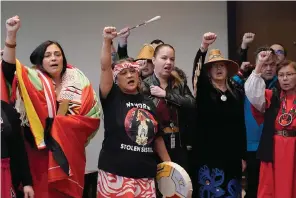  ?? The Associated Press ?? ■ Monie Ordonia, second from left, of the Tulalip Indian Tribe, joins others in singing an honor song after Washington Gov. Jay Inslee signed a bill that creates a first-in-the-nation statewide alert system for missing Indigenous people — particular­ly women — Thursday in Quil Ceda Village, near Marysville, Wash., north of Seattle. The law creates a system similar to Amber Alerts, which are used for missing children in many states.