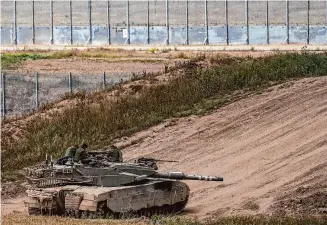  ?? Tsafrir Abayov/Associated Press ?? Israeli soldiers rest on top of their tank on the border with the Gaza Strip, Monday.