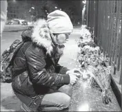  ?? Efrem Lukatsky
Associated Press ?? IN KIEV, Ukraine, a woman in front of the Russian Embassy lights a candle for victims. The passenger list included 214 Russians and three Ukrainians.