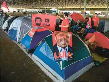  ?? SERGIO LIMA/GETTY-AFP ?? Returning leader in Brazil: Supporters of President-elect Luiz Inacio Lula da Silva camp Saturday at an exhibition hall in Brasilia, Brazil. Lula, 77, defeated far-right President Jair Bolsonaro in October, but many of Bolsonaro’s most die-hard supporters believed the election results to be fraudulent. Lula had been the president of Brazil from 2003 through 2010.