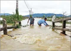  ?? ROBYN BECK/AFP ?? Men wade through a flooded area in the central province of Nghe An. At least 37 people have died and another 40 are missing after floods and landslides hit north and central Vietnam.