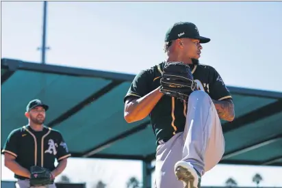  ?? RANDY VAZQUEZ — BAY AREA NEWS GROUP FILE ?? The Oakland Athletics’ Frankie Montas, right, throws a pitch next to teammate Liam Hendriks, left, during spring training at Lew Wolff Training Complex in Mesa, Ariz., on Feb. 13.