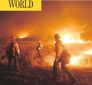  ?? MARK RALSTON / AFP / GETTY IMAGES ?? Fire crews work to contain the destructiv­e wildfire that continues to burn in Southern California.