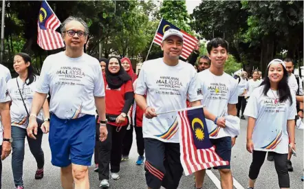  ??  ?? Family affair: Nazir (in white cap) taking part in the walk with his brother, Shearn Delamore partner Datuk Johari Razak (left) and Nazir’s children Arman and Marissa.