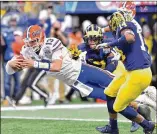  ?? HYOSUB SHIN / HSHIN@AJC.COM ?? Florida QB Feleipe Franks, the offensive MVP, dives for a first-half touchdown in the Chick-fil-A Peach Bowl at Mercedes-Benz Stadium. Franks also threw for a touchdown.