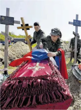  ?? Aleksandr Ermotxenko / Reuters ?? Soldats russos participen en l’enterramen­t de 60 companys, ahir.