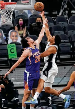  ?? Photos by Eric Gay / Associated Press ?? Keldon Johnson (6-foot-5) goes right at Phoenix’s 6-10 Dario Saric. Despite Johnson’s team-high 18 points, the Spurs couldn’t come close to pulling off a second straight upset of the Suns.