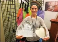  ?? BILL RETTEW JR. – DIGITAL FIRST MEDIA ?? West Chester Public Library staffer Chloe Montgomery shows off two of her favorite specialty cake pans, which are available for patrons to borrow.