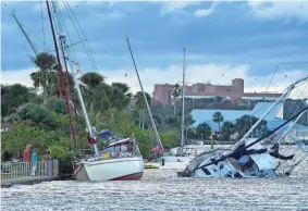  ?? TIM SHORTT/USA TODAY NETWORK ?? Several damaged boats are seen on the Indian River Lagoon at Sand Point Park in Titusville, Florida, following Hurricane Nicole.