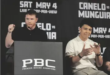  ?? AP PHOTO/DAMIAN DOVARGANES ?? Undisputed super middleweig­ht champion Canelo Alvarez (left) celebrates for Mexico with boxer Jaime Munguía during a news conference in Beverly Hills, Calif., on Tuesday.